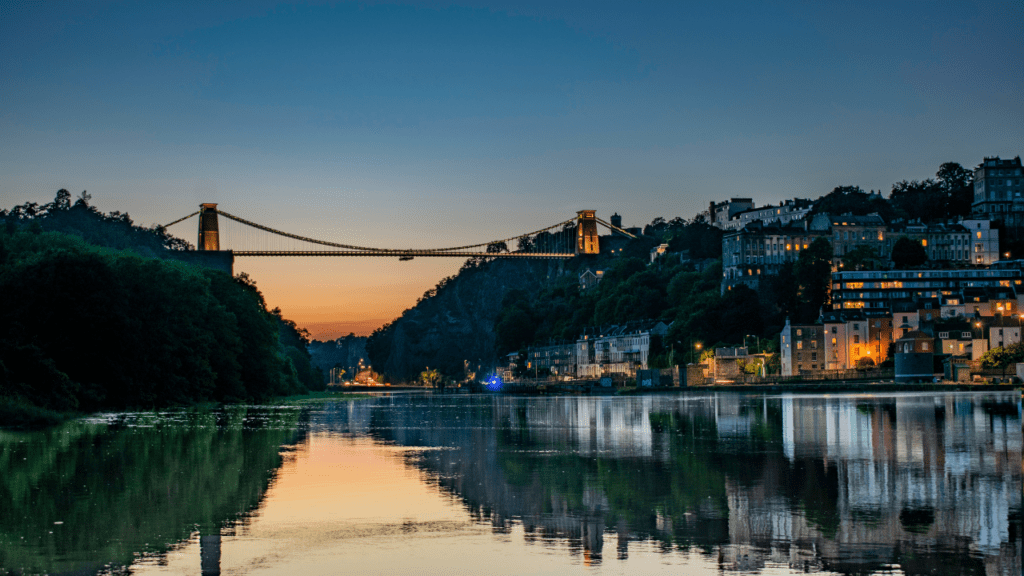 clifton suspension bridge from afar with sunset behind it
