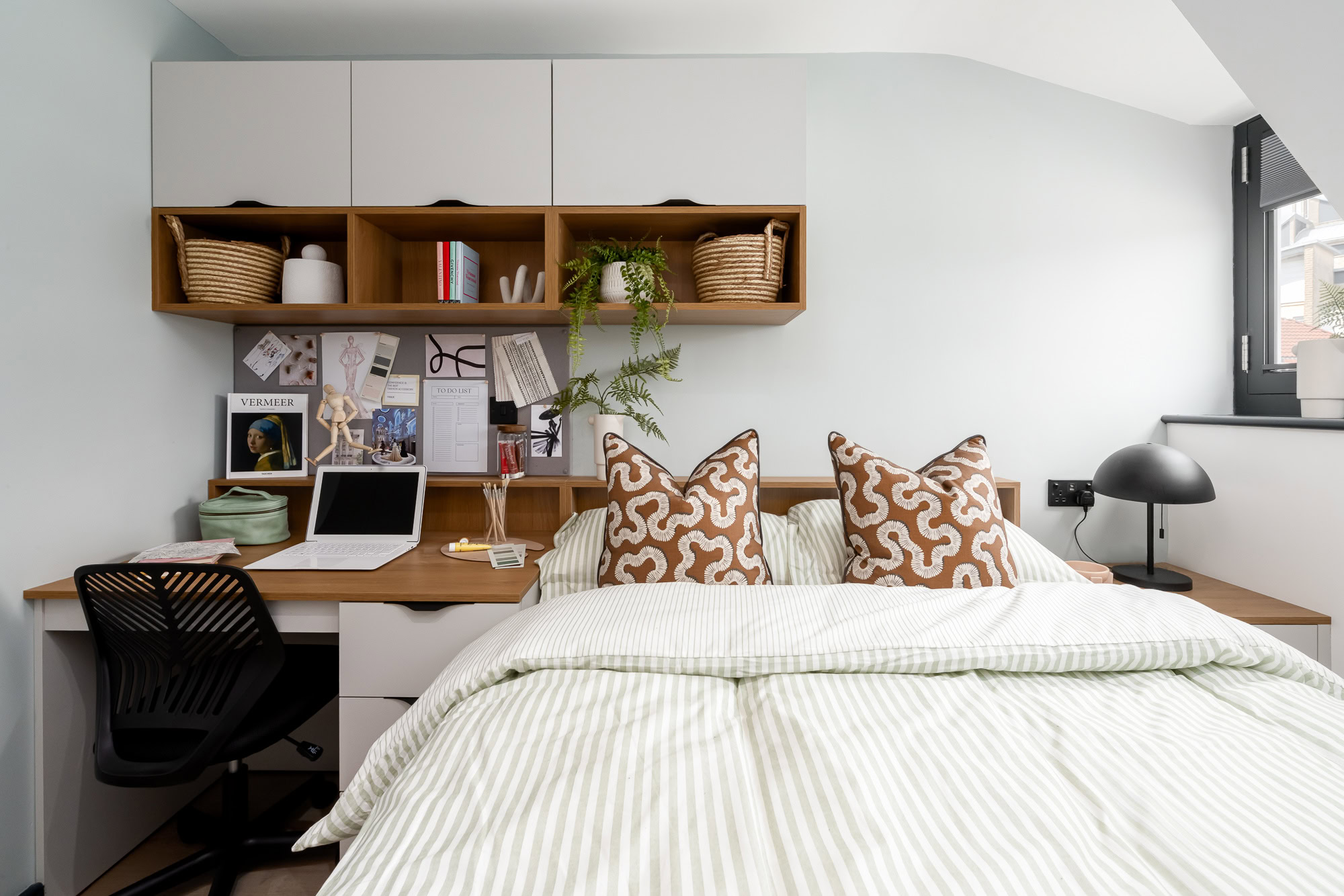 A bedroom with a desk and a bed.