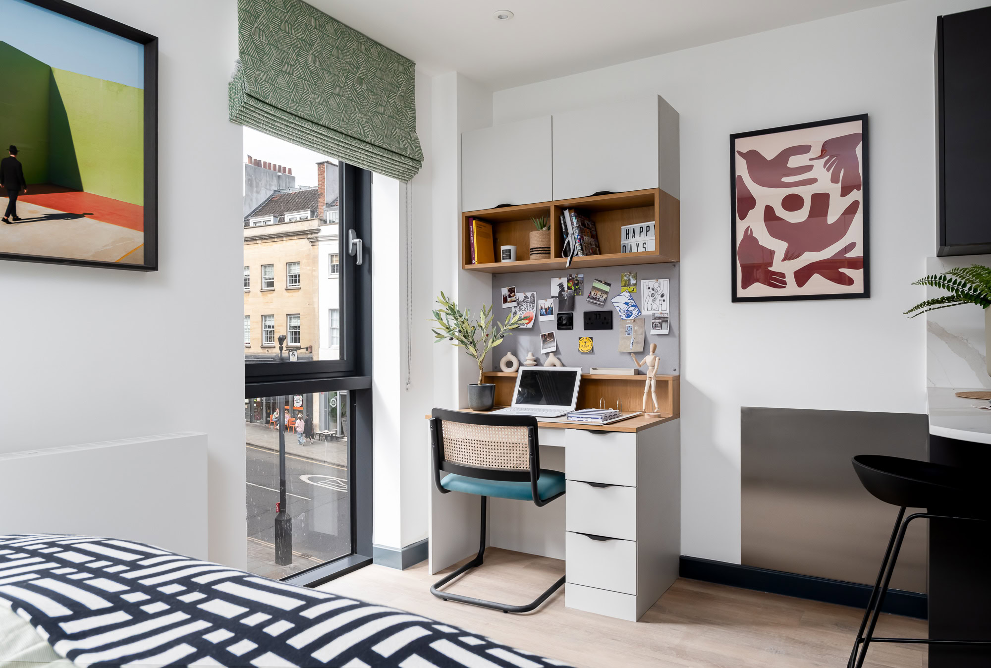 A bedroom with green walls and white furniture.