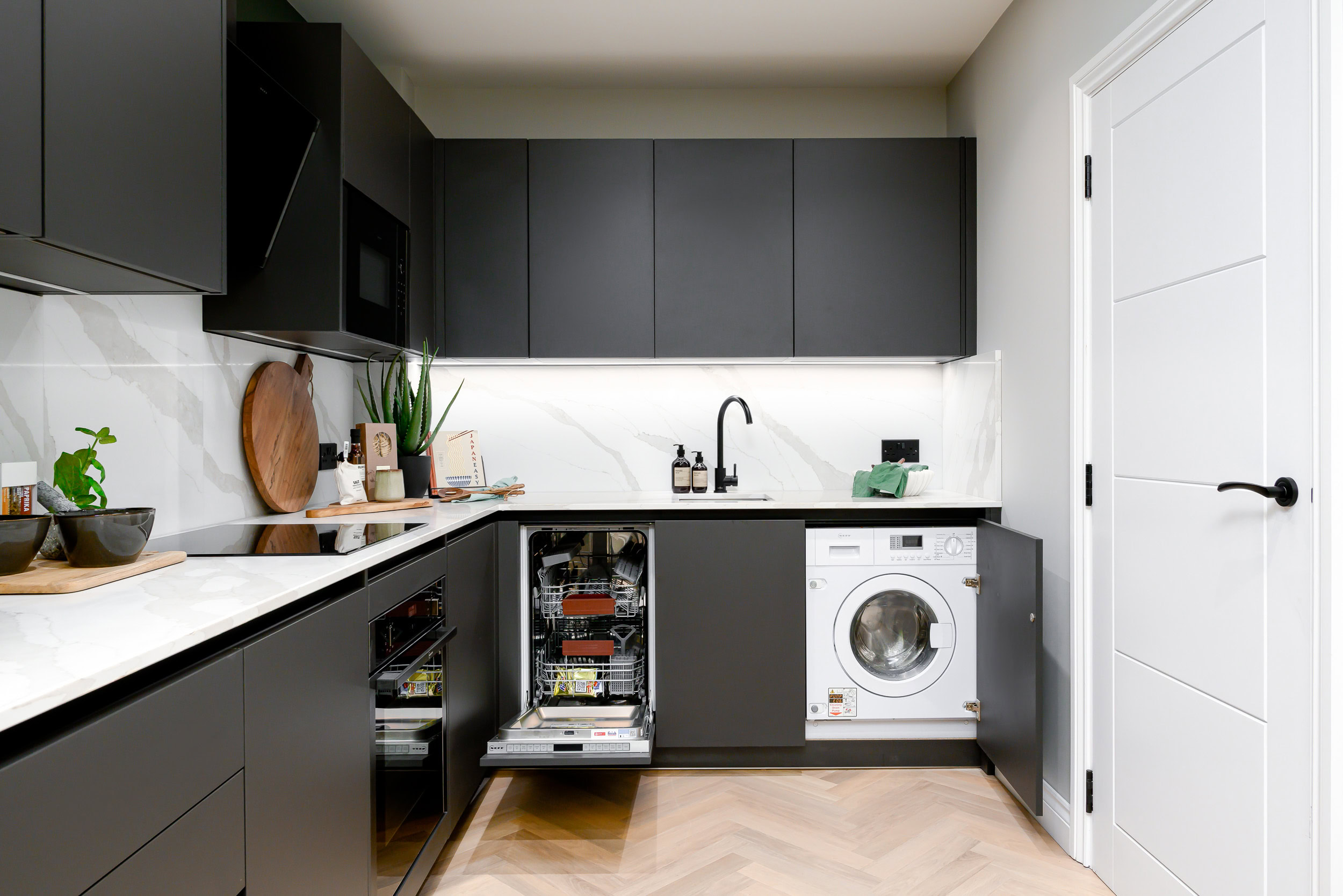 A modern kitchen equipped with a washer and dryer, illustrating a functional area for both cooking and laundry tasks.