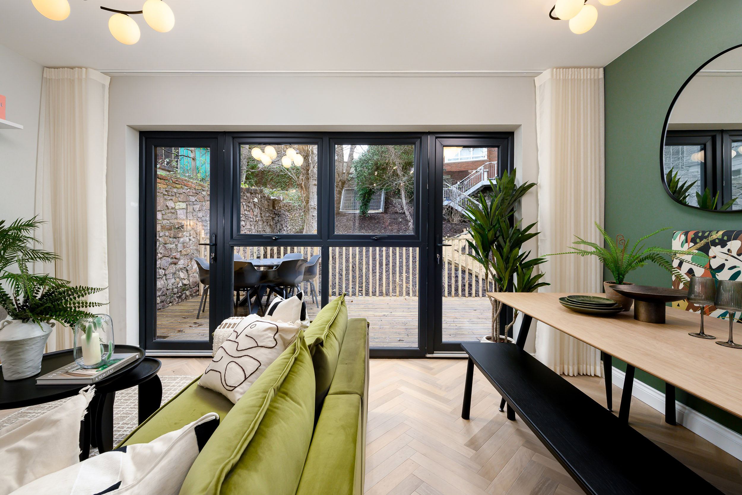 A stylish living room with a green couch and a table, designed for comfort and relaxation.