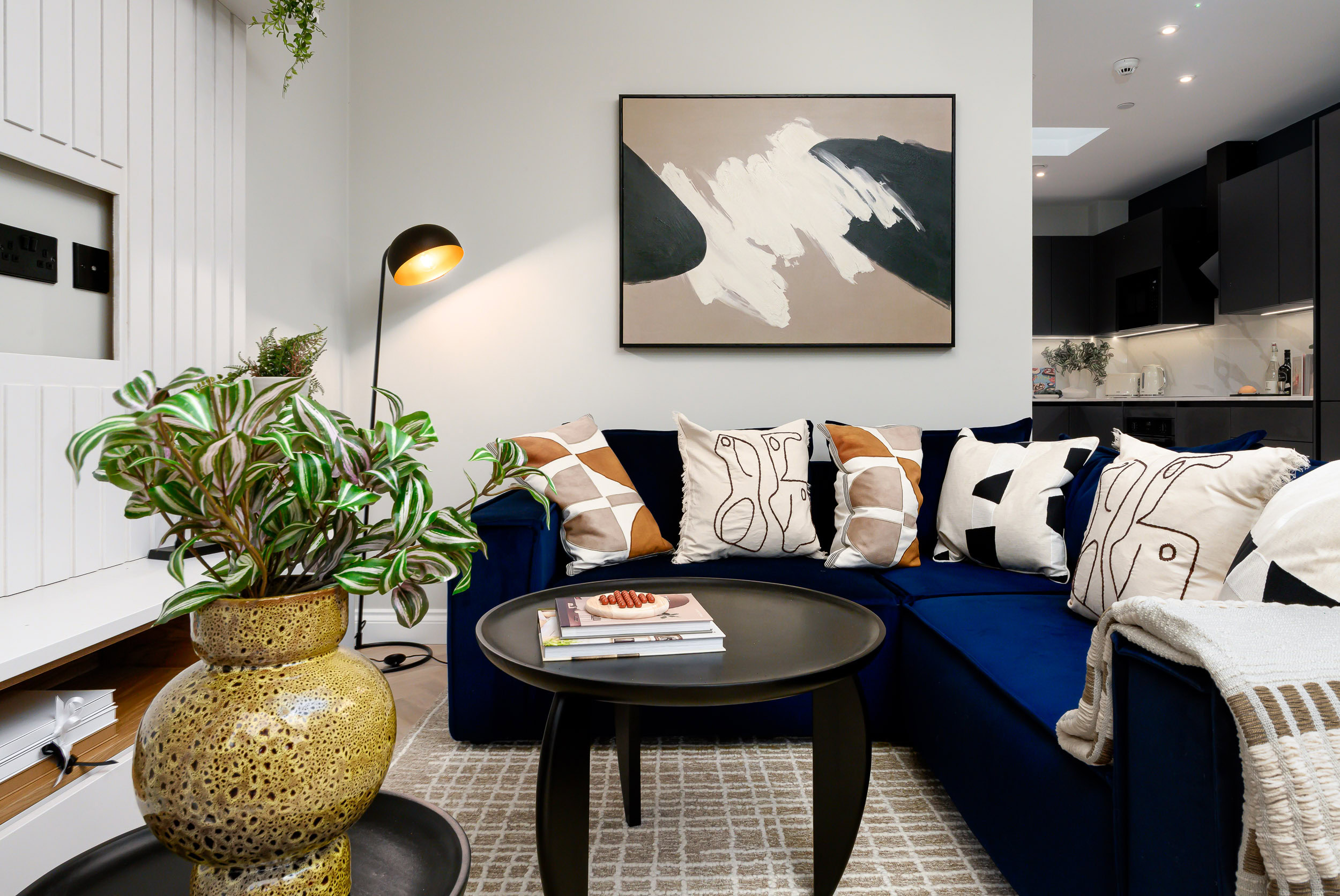 A living room featuring a blue couch and a sleek black coffee table.
