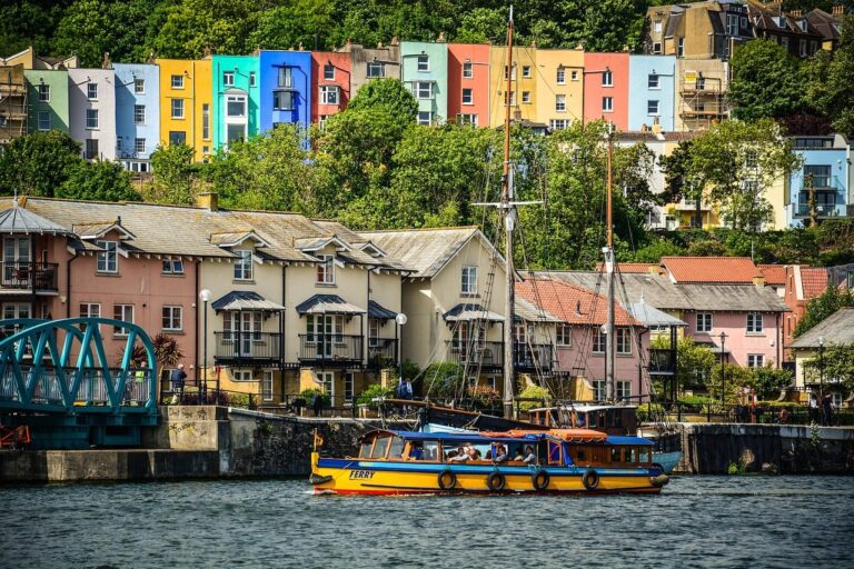 Colourful houses on the hillside above Bristol's harbour, with a ferry
