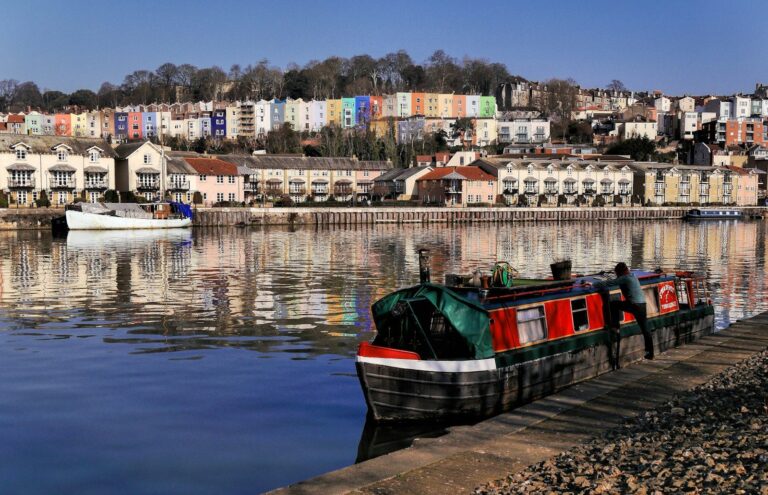 A narrowboat on the Floating Harbour with pastel houses behind