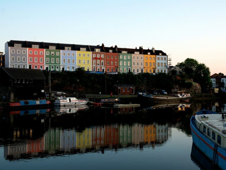A pastel terrace reflected in the harbour at dusk