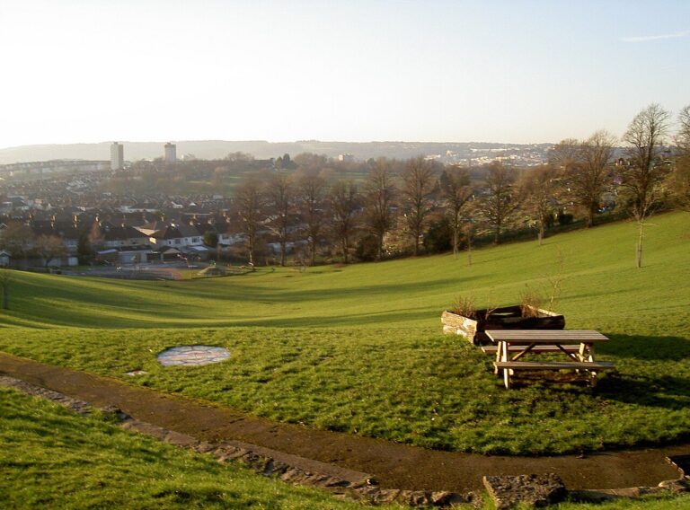 A picnic bench on a hillside lawn with a long view over Bristol